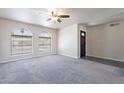 Spacious living room with arched windows, ceiling fan, and neutral-toned carpet at 2502 E Malibu Dr, Tempe, AZ 85282