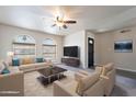 Bright living room featuring two couches, coffee table, ceiling fan, and arched windows at 2502 E Malibu Dr, Tempe, AZ 85282