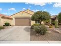Attractive home exterior with a two-car garage, desert landscaping, and a neutral color scheme at 27030 W Escuda Dr, Buckeye, AZ 85396