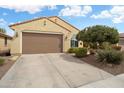 Inviting home exterior with a spacious driveway, desert landscaping, and a two-car garage at 27030 W Escuda Dr, Buckeye, AZ 85396