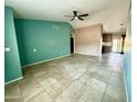 Bright living room with neutral tile flooring featuring a ceiling fan and an opening to the kitchen at 2705 E Rock Wren Rd, Phoenix, AZ 85048