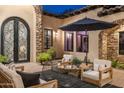 Charming courtyard with stone accents, a covered patio, and outdoor seating beneath a dark umbrella at 2782 E Citadel Ct, Gilbert, AZ 85298