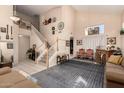 Bright living room with high ceilings, elegant staircase, tile floors, and large rug for a comfortable atmosphere at 2841 S Esmeralda Cir, Mesa, AZ 85212