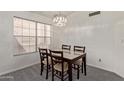 Bright dining room boasts a modern chandelier and a large window with plenty of natural light at 2904 E Ludlow Dr, Phoenix, AZ 85032