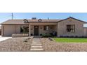 Charming home showcasing desert landscaping and a stone pathway leading to the cozy front porch at 3301 E Sharon Dr, Phoenix, AZ 85032
