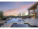 Relaxing backyard oasis with a shimmering pool and spa, perfect for entertaining under colorful sunset at 36389 N 105Th Pl, Scottsdale, AZ 85262