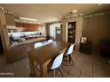 Comfortable dining area featuring tile floors, neutral paint and wood table with modern white chairs at 3937 W Stella Ln, Phoenix, AZ 85019