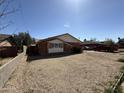 Quaint single-story home featuring a brick exterior, well-maintained landscaping and an expansive gravel driveway at 3937 W Stella Ln, Phoenix, AZ 85019