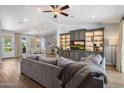 Spacious living room featuring an entertainment center with built-in shelves, fan, and hardwood floors at 4110 E Indianola Ave, Phoenix, AZ 85018