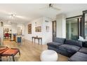 Open floor plan of living room, featuring a large sectional, modern lighting, and wood floors at 4808 N 24Th St # 303, Phoenix, AZ 85016