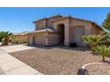 Attractive home featuring a three-car garage, desert landscaping, and a neutral color palette at 5811 W Irma Ln, Glendale, AZ 85308