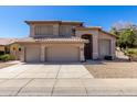 Exterior of a stucco home featuring a three-car garage, well-maintained landscaping, and a tile roof at 5811 W Irma Ln, Glendale, AZ 85308