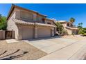 A well-maintained stucco home showcasing a spacious three-car garage and mature landscaping at 5811 W Irma Ln, Glendale, AZ 85308