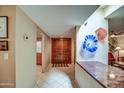 Bright, airy hallway with tile flooring leads to a double-door entrance at 7807 E Granada Rd, Scottsdale, AZ 85257
