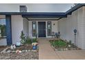 Charming front entryway with a secure metal door, desert landscaping, and accent decor at 815 E Paradise Ln, Phoenix, AZ 85022