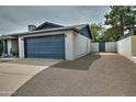 View of the side of a single Gathering home with a blue garage door and side parking area at 815 E Paradise Ln, Phoenix, AZ 85022