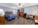 Bedroom with wood floors, bed with blue patterned comforter and a ceiling fan at 9333 E University Dr # 113, Mesa, AZ 85207