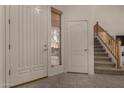 Bright entryway featuring tile flooring, a white front door, adjacent window with blinds and a staircase leading to the upper level at 1101 S Hazel St, Gilbert, AZ 85296