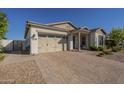 Well-maintained home featuring a spacious driveway, two car garage, and desert landscaping at 10134 E Supernova Dr, Mesa, AZ 85212