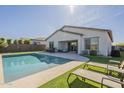Inviting backyard oasis featuring a sparkling pool, lounge chairs, and a covered patio perfect for outdoor entertaining at 10134 E Supernova Dr, Mesa, AZ 85212