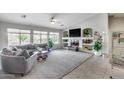 Spacious living room featuring large windows, tile floors, a ceiling fan, and a decorative fireplace at 11502 E Rafael Ave, Mesa, AZ 85212