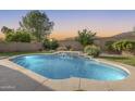 Inviting backyard pool features a serene waterfall, surrounding stone coping, and lush landscaping at 11502 E Rafael Ave, Mesa, AZ 85212