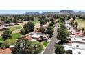 Expansive aerial view of residential homes next to a golf course, offering scenic community living with mountain views at 11837 N 40Th Pl, Phoenix, AZ 85028
