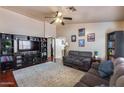Cozy living room features dark wood floors, neutral walls, ceiling fan and built-in media center, ideal for relaxing at 12048 W Dahlia Dr, El Mirage, AZ 85335