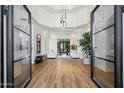 Grand foyer featuring high ceilings, a modern chandelier, and double glass entry doors at 12055 E Clinton St, Scottsdale, AZ 85259
