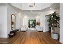Elegant living room with hardwood floors, a tray ceiling, and bright natural light at 12055 E Clinton St, Scottsdale, AZ 85259