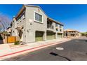 Townhouse exterior features a well-maintained facade, multiple garages, and tidy landscaping under a clear blue sky at 1330 S Aaron -- # 218, Mesa, AZ 85209