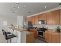 Bright kitchen features stainless appliances, wood cabinets, granite counters and a breakfast bar with seating at 1330 S Aaron -- # 218, Mesa, AZ 85209
