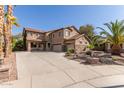 Charming two-story home with a spacious three-car garage, a large driveway and mature palm trees at 13514 W Banff Ln, Surprise, AZ 85379