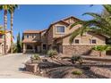 Inviting two-story home featuring desert landscaping, and a large driveway, perfect for multiple vehicles at 13514 W Banff Ln, Surprise, AZ 85379
