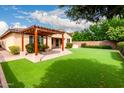 Enjoy outdoor living in this backyard with artificial turf, a covered patio, and easy access to the house at 1437 E Flamingo Way, Gilbert, AZ 85297