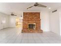 Bright living room featuring a charming brick fireplace and tile floors at 1523 W Glenn Dr, Phoenix, AZ 85021