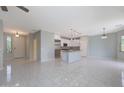 Open-concept living area with tile flooring, recessed lighting, and neutral paint providing a bright and airy space at 18051 W Port Royale Ln, Surprise, AZ 85388
