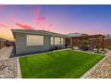 Lush backyard with artificial turf and a covered patio, perfect for outdoor living at 18956 W Laurel Ln, Surprise, AZ 85388