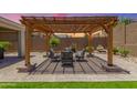Backyard oasis featuring a cozy covered patio, lush landscaping and room to entertain at 18956 W Laurel Ln, Surprise, AZ 85388