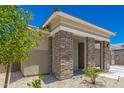 Front exterior featuring stone accents, desert landscaping, and a charming covered porch at 18956 W Laurel Ln, Surprise, AZ 85388