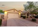 Well-lit home showcasing a clean driveway, neutral exterior, and desert landscaping at 2123 S Bristol Dr, Mesa, AZ 85209