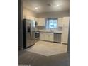 Well-lit kitchen with stainless steel appliances, white cabinets, and modern tiled flooring at 2244 W Laurie Ln, Phoenix, AZ 85021