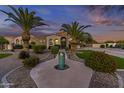 Inviting single-story home featuring palm trees, desert landscaping, and a front yard fountain at 24695 S 195Th Way, Queen Creek, AZ 85142