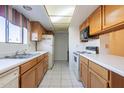 Well lit kitchen with white appliances, neutral countertop and wood cabinets at 3031 N Civic Center Plz # 255, Scottsdale, AZ 85251