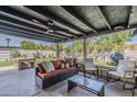 Relaxing covered patio with comfortable seating, ceiling fan, outdoor lighting, and views of the landscaped backyard at 3246 E Palm Ln, Phoenix, AZ 85008