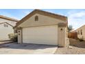 Neutral colored one story home featuring a two car garage with desert landscaping at 3323 W Fraktur Rd, Phoenix, AZ 85041