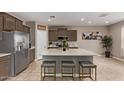Modern kitchen featuring an island with seating, stainless steel appliances, and sleek, stylish cabinets at 3818 N 306Th Ave, Buckeye, AZ 85396