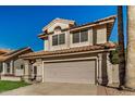 A view of a two-story home with a tile roof and an attached two-car garage at 6857 S Roosevelt St, Tempe, AZ 85283