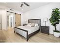 Serene bedroom with a modern bed, light hardwood floors, and a sliding barn door to the ensuite bathroom at 7955 E Chaparral Rd # 116, Scottsdale, AZ 85250