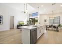 Open-concept kitchen featuring a large island with marble countertops, stainless steel appliances, and modern lighting at 7955 E Chaparral Rd # 116, Scottsdale, AZ 85250